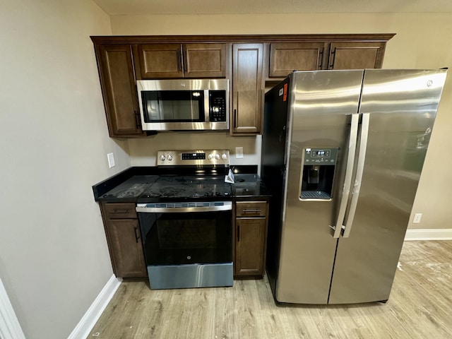 kitchen with baseboards, light wood finished floors, dark brown cabinetry, and stainless steel appliances