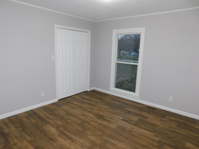 unfurnished room featuring crown molding, baseboards, visible vents, and dark wood-style floors
