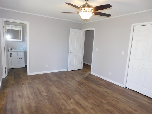 unfurnished bedroom featuring ceiling fan, crown molding, dark wood finished floors, baseboards, and a closet