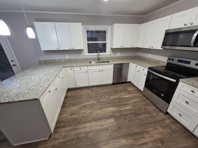 kitchen with light stone countertops, appliances with stainless steel finishes, ornamental molding, and a sink