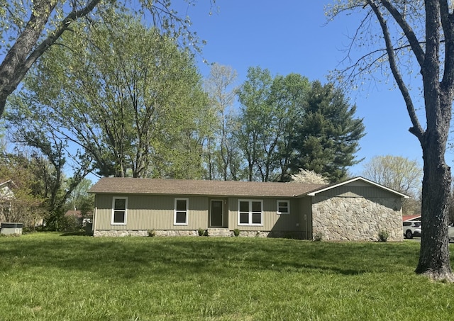 ranch-style house with roof with shingles, stone siding, and a front lawn