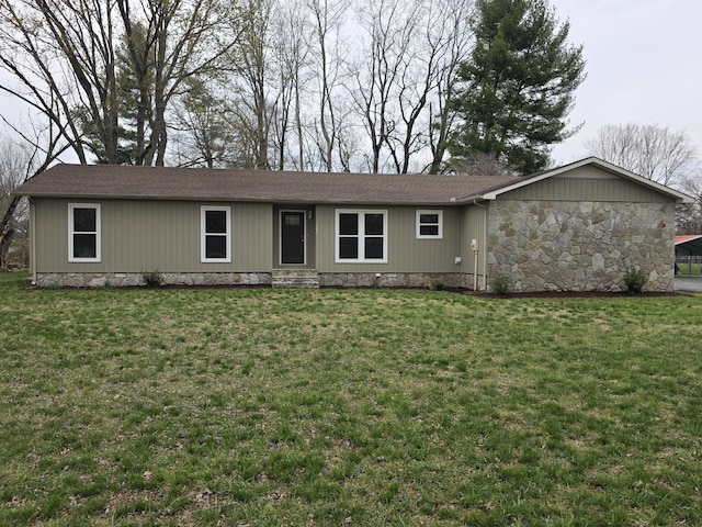 ranch-style house featuring roof with shingles, stone siding, and a front yard