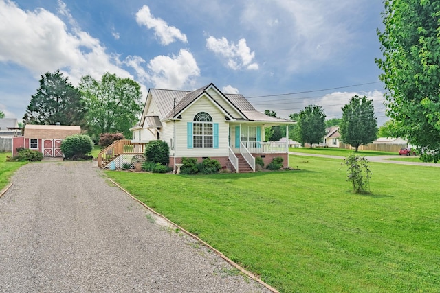single story home featuring an outdoor structure, crawl space, a front yard, covered porch, and metal roof