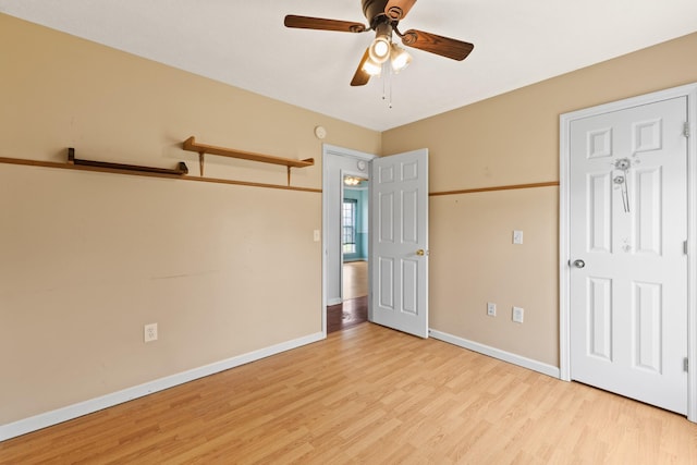 unfurnished bedroom featuring baseboards, ceiling fan, and light wood-type flooring