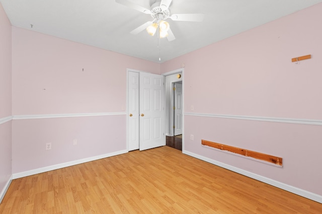 empty room with baseboards, a ceiling fan, and wood finished floors