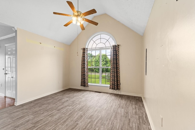 spare room with baseboards, ceiling fan, vaulted ceiling, and wood finished floors