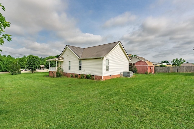 view of side of property with a yard, crawl space, fence, and metal roof