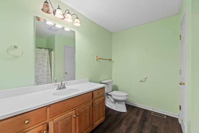 full bathroom with visible vents, vanity, wood finished floors, toilet, and baseboards