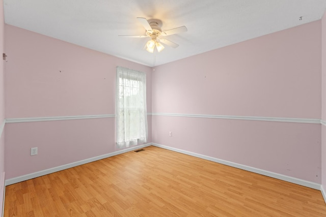 empty room with baseboards, ceiling fan, and wood finished floors