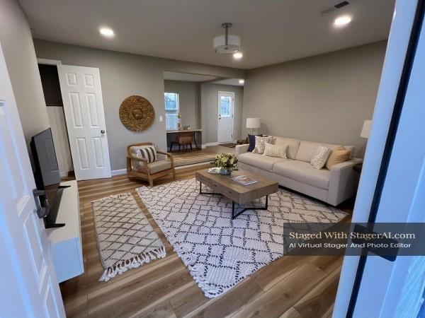 living room featuring recessed lighting, baseboards, visible vents, and wood finished floors