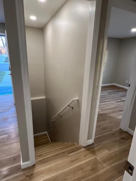 stairway with baseboards, recessed lighting, and wood finished floors