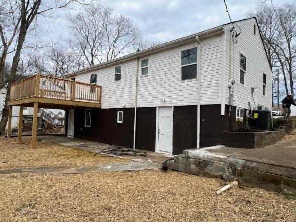 rear view of property featuring stairway, a deck, cooling unit, and a patio