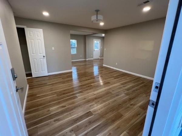 unfurnished room featuring baseboards, recessed lighting, wood finished floors, and visible vents