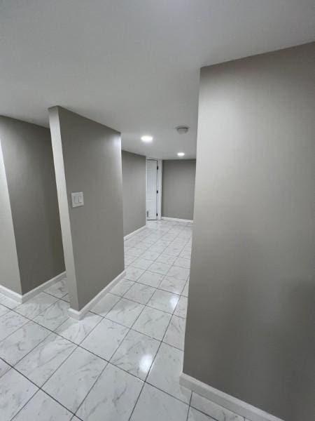 hall featuring baseboards, recessed lighting, and marble finish floor