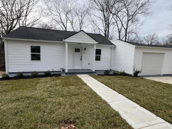 view of front of home featuring driveway and a front lawn