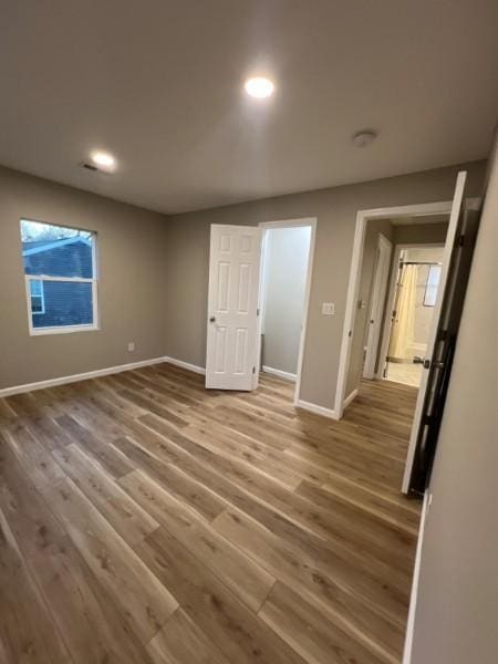 interior space with baseboards, recessed lighting, and wood finished floors