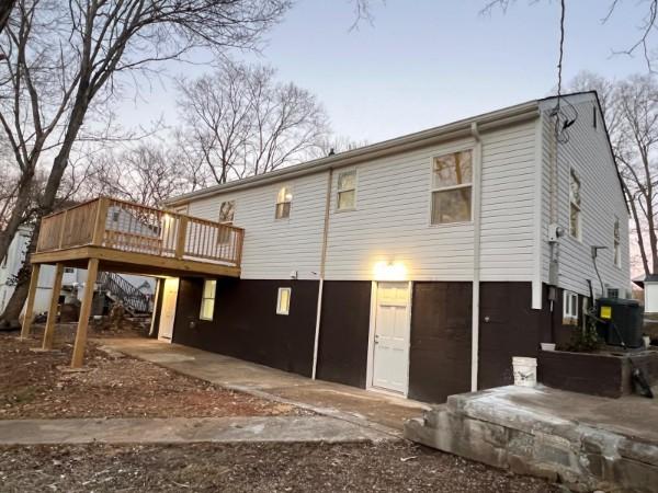 back of property featuring central air condition unit and a wooden deck