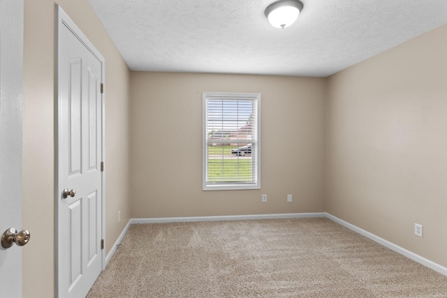 unfurnished room with baseboards, carpet flooring, and a textured ceiling
