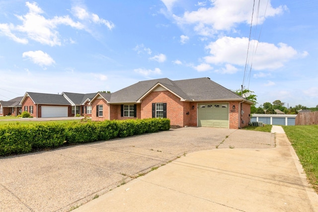single story home with brick siding, a shingled roof, concrete driveway, an attached garage, and central air condition unit
