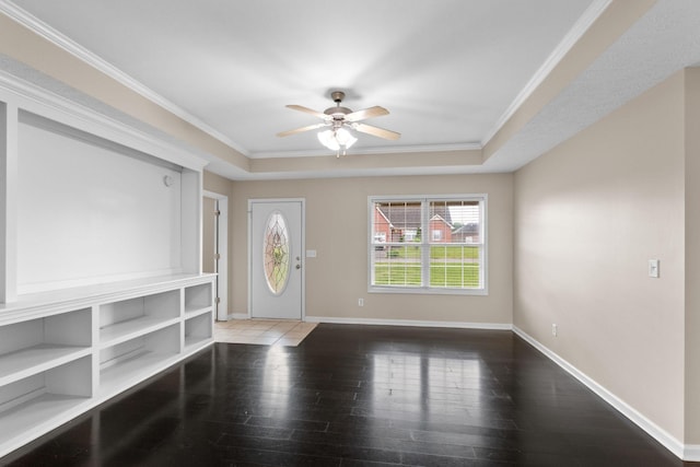 entryway featuring crown molding, ceiling fan, hardwood / wood-style floors, baseboards, and a tray ceiling