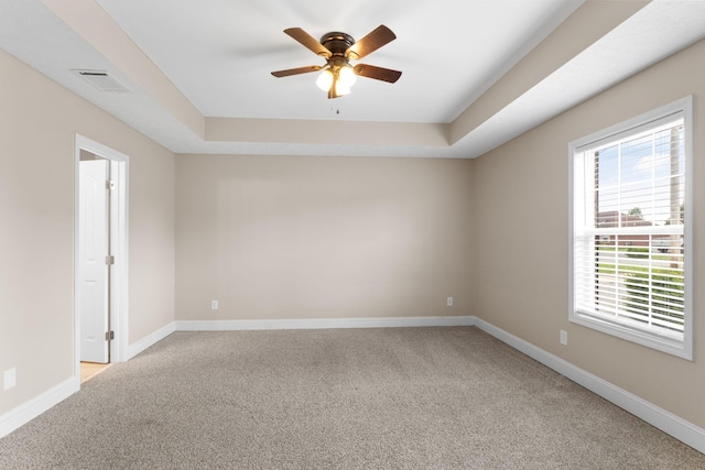 spare room featuring a ceiling fan, baseboards, visible vents, and light carpet