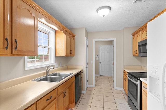 kitchen featuring light countertops, light tile patterned floors, appliances with stainless steel finishes, and a sink
