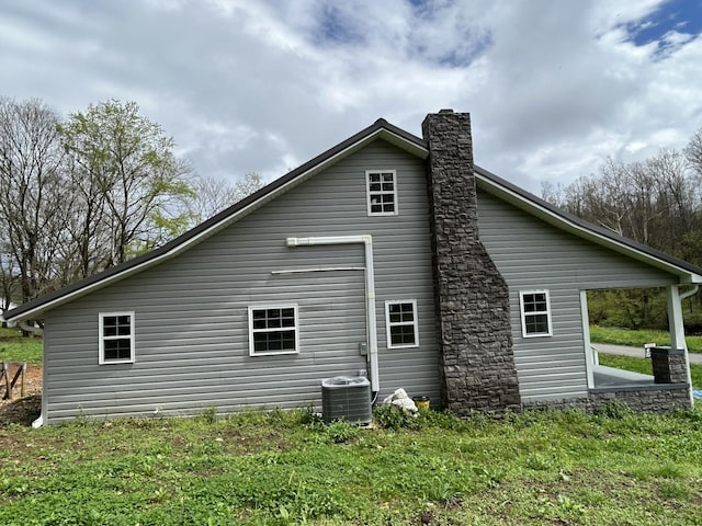 view of property exterior with central air condition unit and a chimney