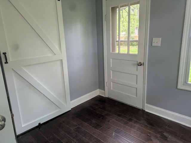 doorway featuring baseboards and dark wood finished floors