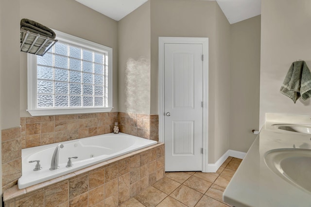 full bathroom with a sink, tile patterned floors, baseboards, and a tub with jets