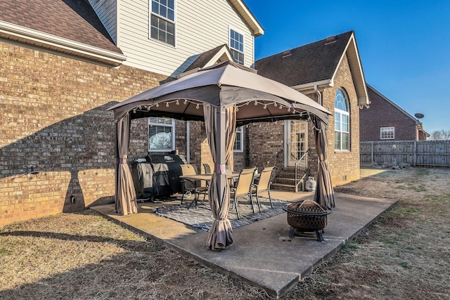 view of patio with a gazebo, an outdoor fire pit, fence, and entry steps