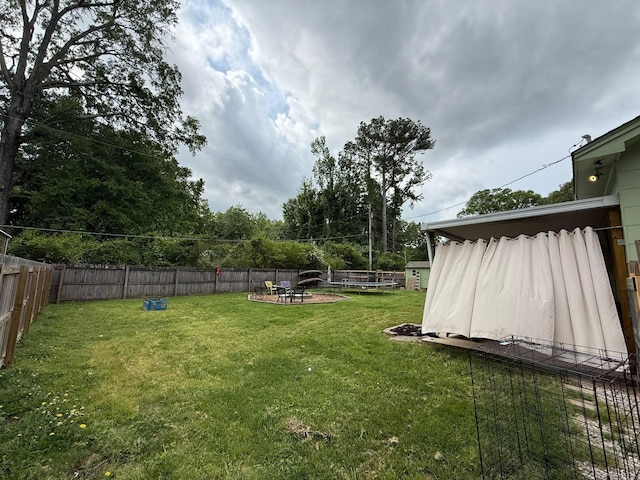 view of yard featuring a fenced backyard and a fire pit