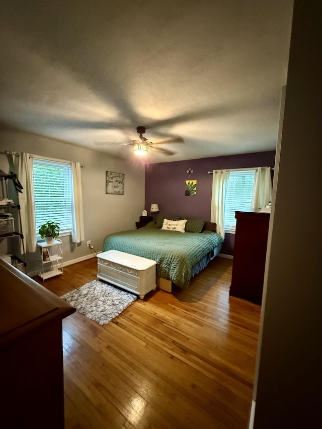 bedroom featuring baseboards, ceiling fan, and wood finished floors