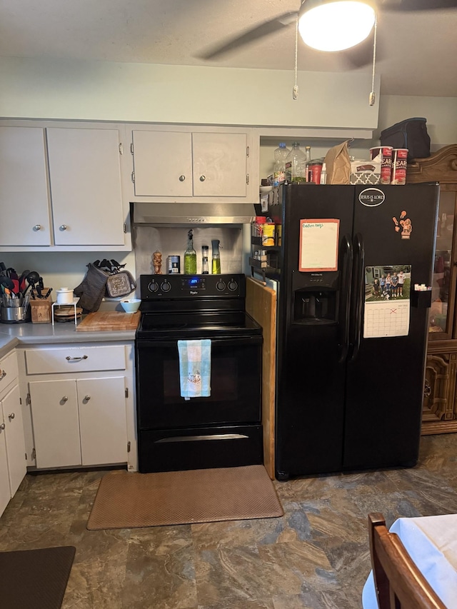 kitchen featuring stone finish floor, light countertops, under cabinet range hood, white cabinets, and black appliances