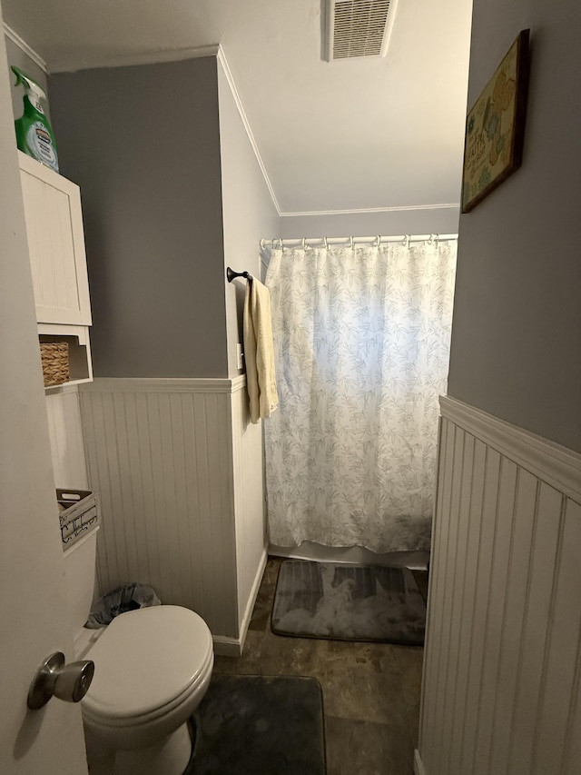 full bath with ornamental molding, wainscoting, toilet, and visible vents