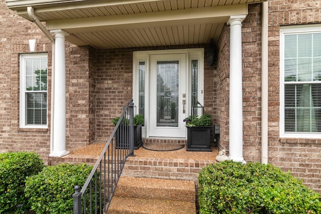 doorway to property featuring brick siding