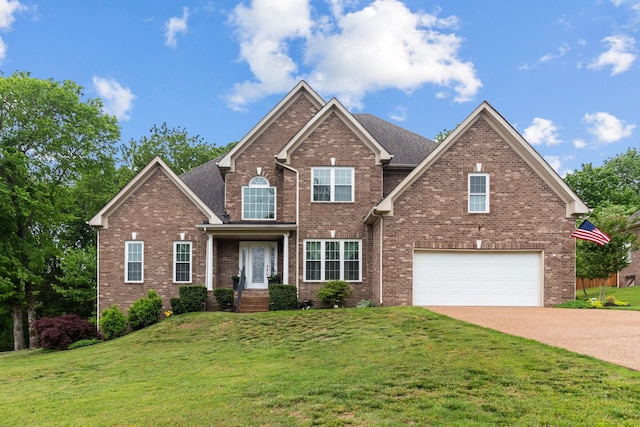 view of front of property featuring an attached garage, a front yard, driveway, and brick siding