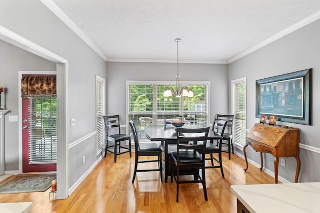 dining area featuring baseboards, a chandelier, ornamental molding, and light wood finished floors
