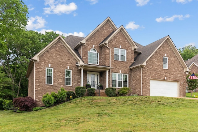 view of front of house with brick siding, an attached garage, driveway, and a front yard