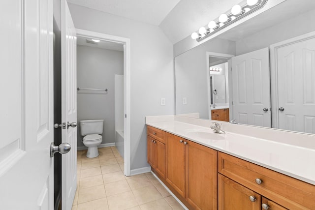 bathroom with a washtub, tile patterned floors, baseboards, vanity, and toilet