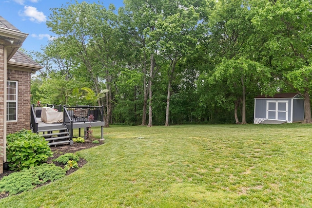 view of yard featuring an outdoor structure, a deck, and a shed