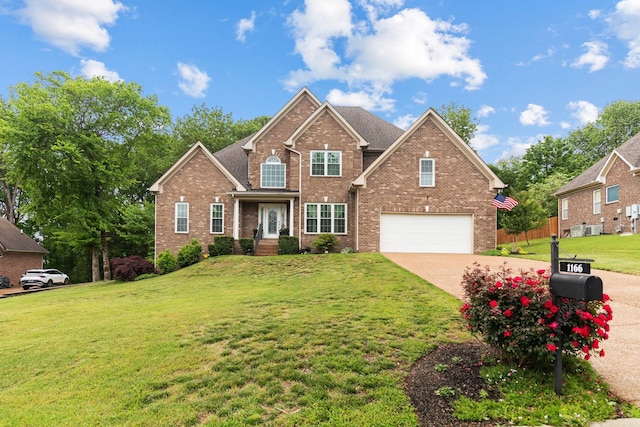 traditional-style home featuring brick siding, a garage, driveway, and a front yard