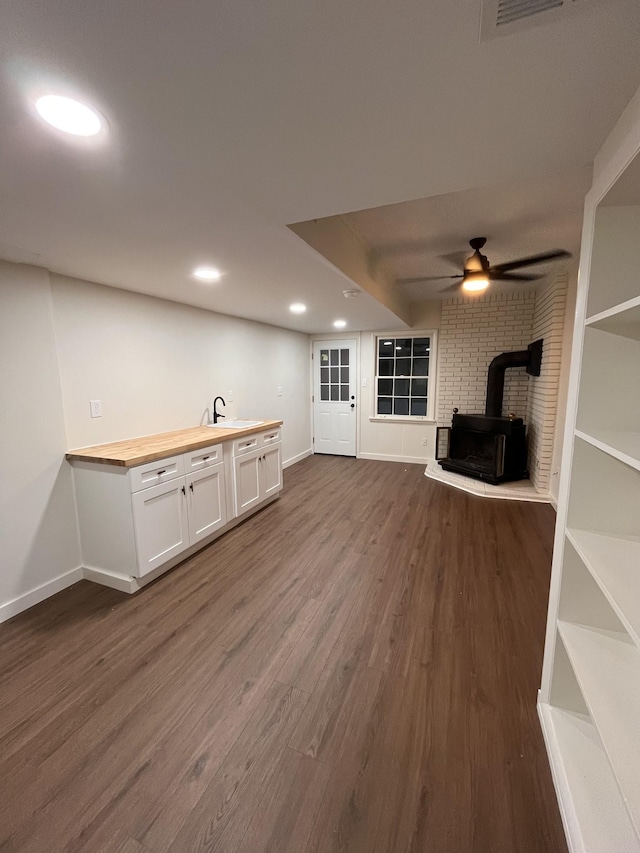 361 Binkley Dr, Nashville, TN 37211 - unfurnished living room featuring a wood stove, a sink, dark wood-type flooring, baseboards, and a ceiling fan