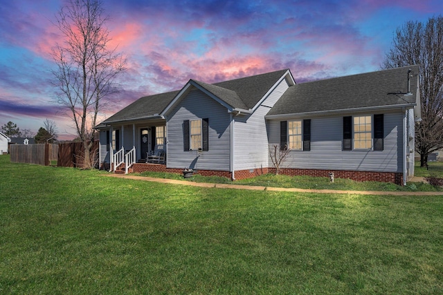 single story home with a porch, a lawn, and fence