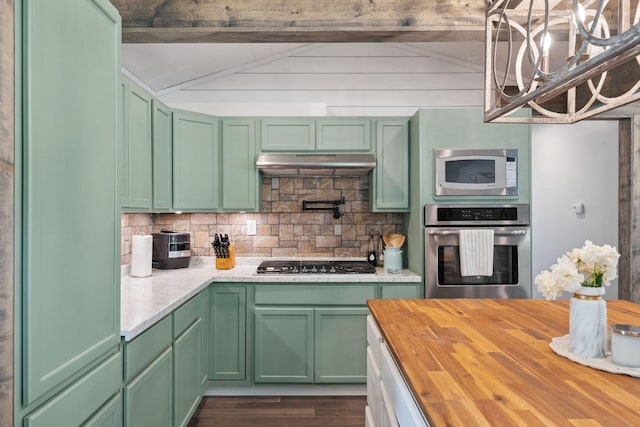 kitchen featuring under cabinet range hood, butcher block countertops, appliances with stainless steel finishes, and green cabinets