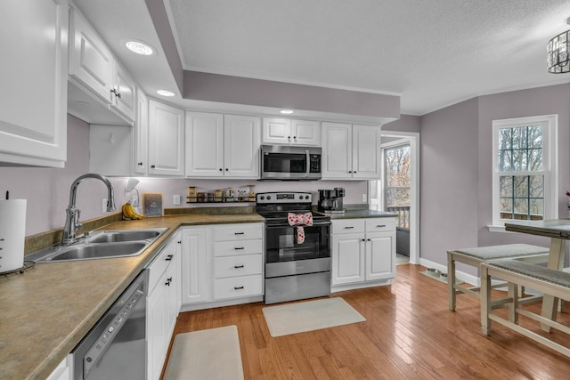 1204 Wood Pines Ln, Hixson, TN 37343 - kitchen featuring appliances with stainless steel finishes, a sink, light wood finished floors, white cabinets, and recessed lighting
