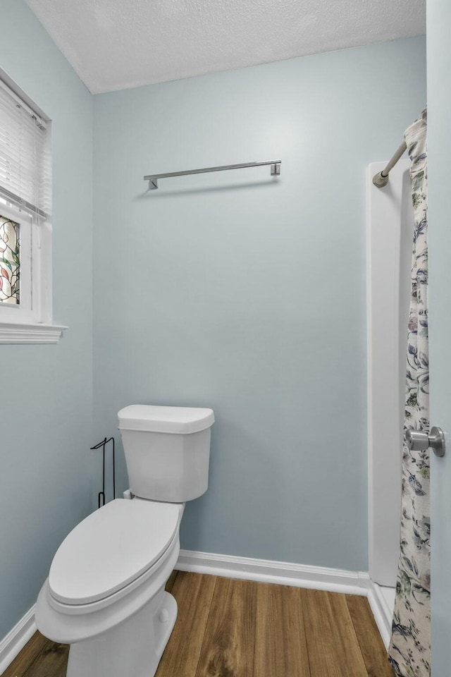 1204 Wood Pines Ln, Hixson, TN 37343 - full bathroom with wood finished floors, toilet, baseboards, and curtained shower