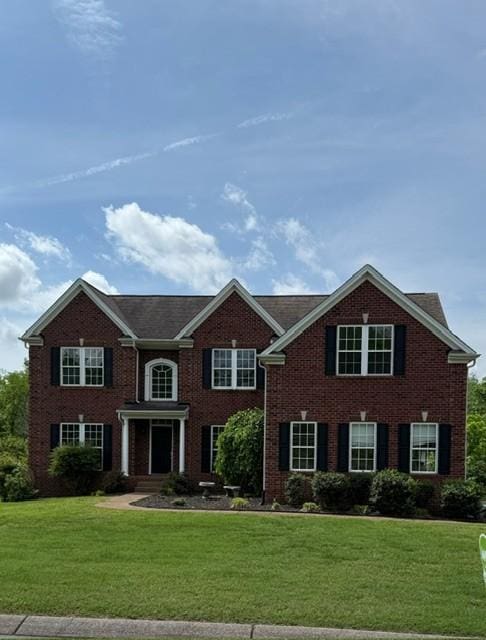 view of front of home with a front yard and brick siding