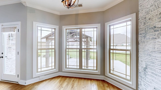 entryway with baseboards, ornamental molding, a healthy amount of sunlight, and wood finished floors