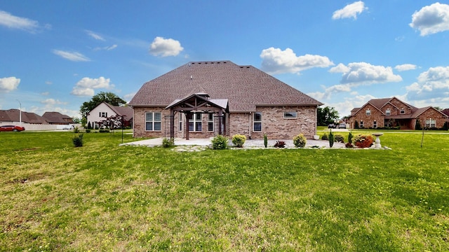 back of property featuring a patio area, brick siding, and a lawn