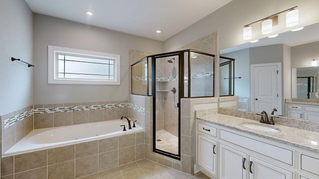 bathroom featuring vanity, a garden tub, a shower stall, and tile patterned flooring